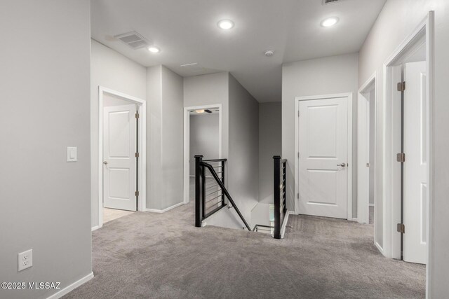 hallway featuring carpet, visible vents, recessed lighting, an upstairs landing, and baseboards