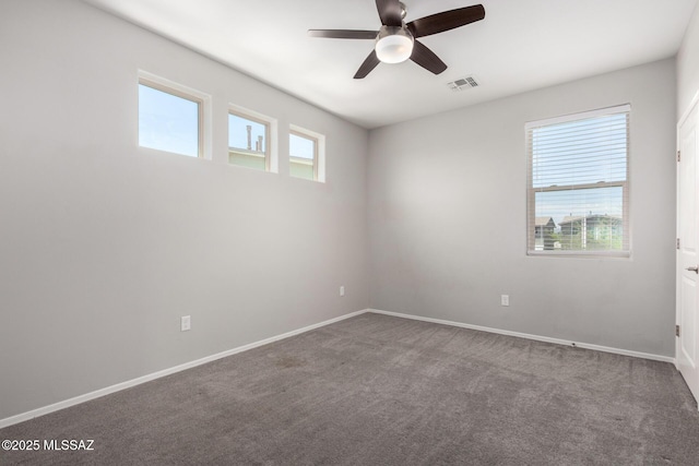 unfurnished room with visible vents, ceiling fan, carpet flooring, and baseboards