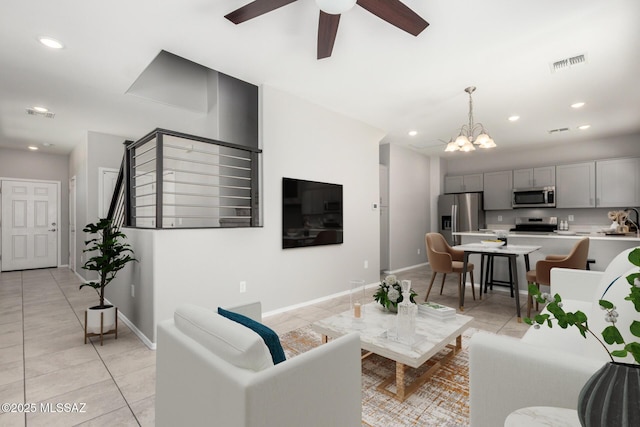 living area with recessed lighting, visible vents, light tile patterned floors, baseboards, and ceiling fan with notable chandelier