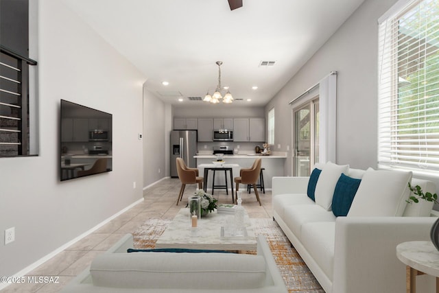 living room with light tile patterned flooring, baseboards, visible vents, an inviting chandelier, and recessed lighting