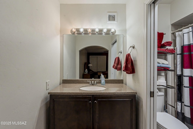 full bathroom with toilet and vanity