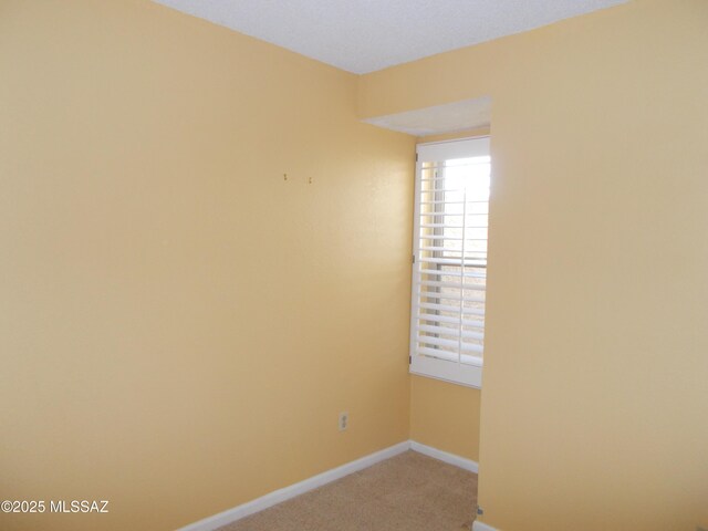 spare room with carpet flooring and baseboards