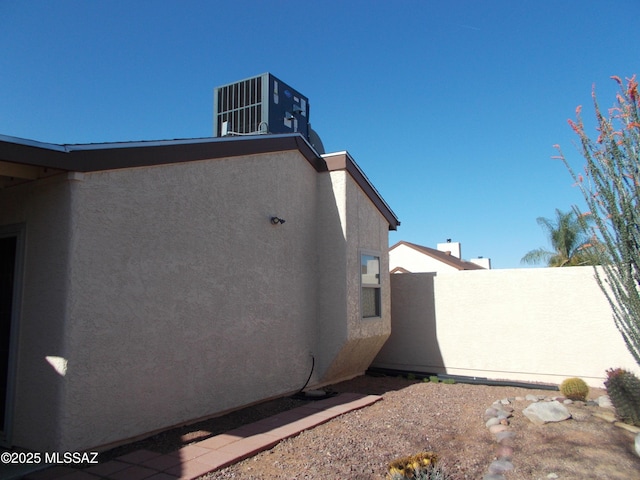 view of home's exterior with central AC and stucco siding