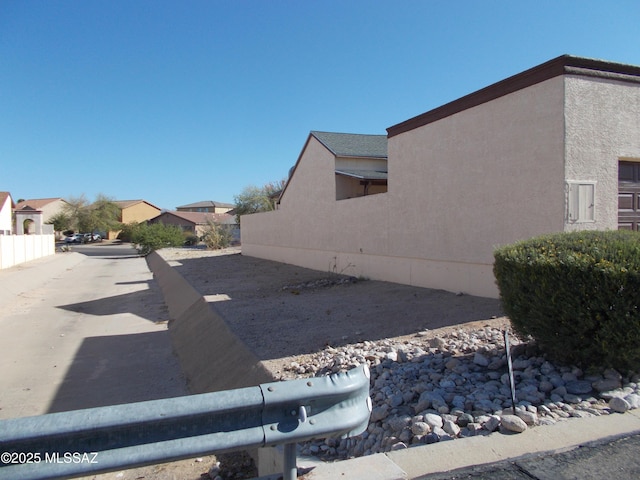 view of property exterior featuring fence and stucco siding