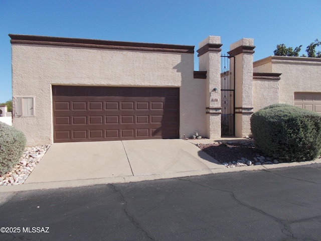view of front of house featuring stucco siding, an attached garage, and concrete driveway