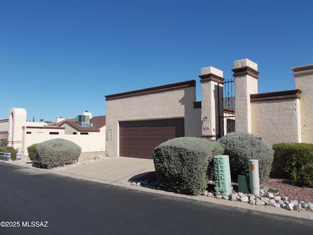 modern home with a garage, stucco siding, central air condition unit, and concrete driveway