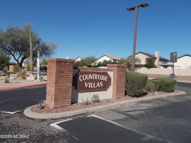 community / neighborhood sign featuring fence