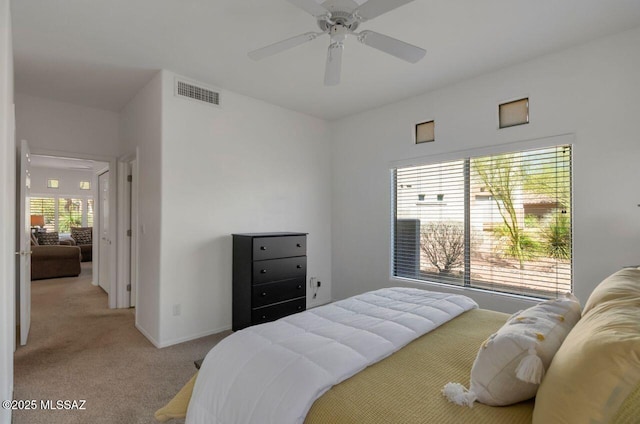 carpeted bedroom featuring baseboards, visible vents, and ceiling fan