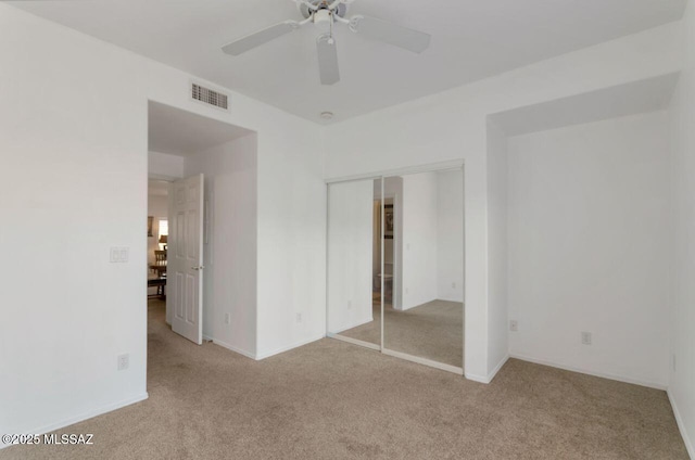 unfurnished bedroom with baseboards, carpet, a closet, and visible vents