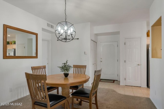 dining area with visible vents, a chandelier, light tile patterned floors, and light colored carpet