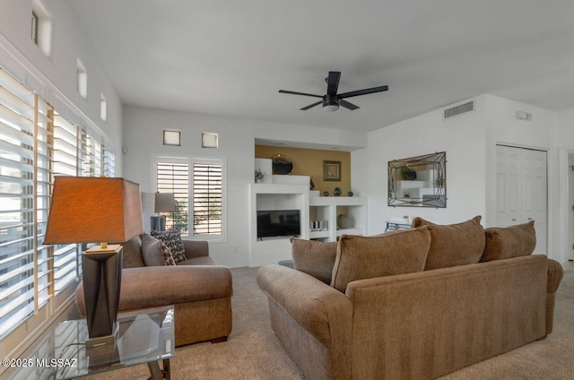 living room with carpet flooring, visible vents, and a ceiling fan