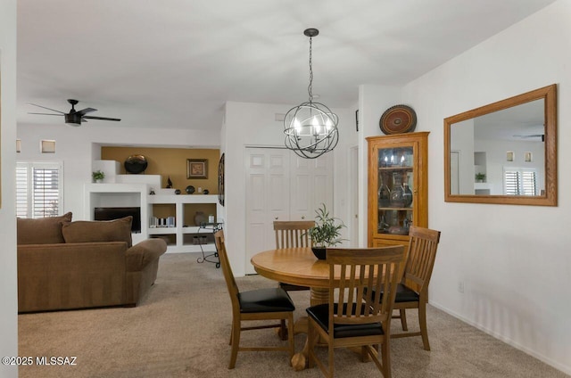 dining area with ceiling fan with notable chandelier and carpet floors
