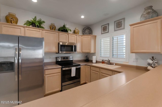 kitchen featuring light countertops, a sink, light brown cabinetry, appliances with stainless steel finishes, and recessed lighting