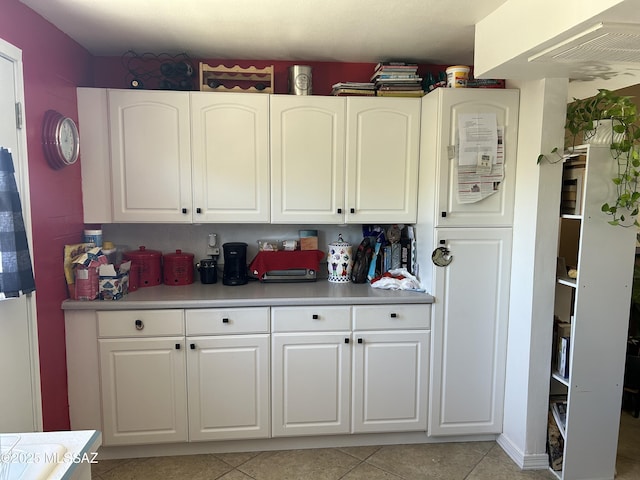 kitchen featuring white cabinets, light countertops, and light tile patterned floors