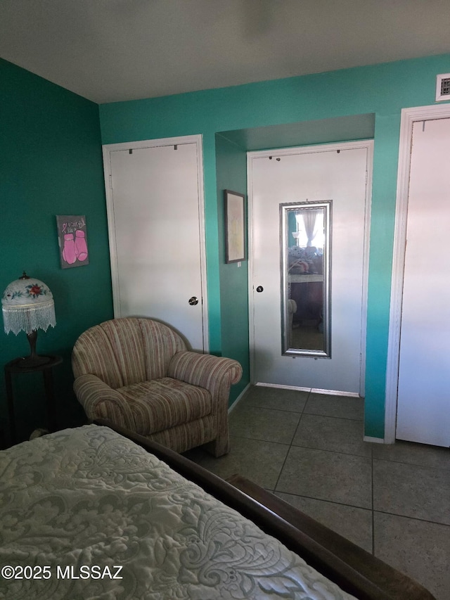 bedroom with visible vents, tile patterned floors, and baseboards