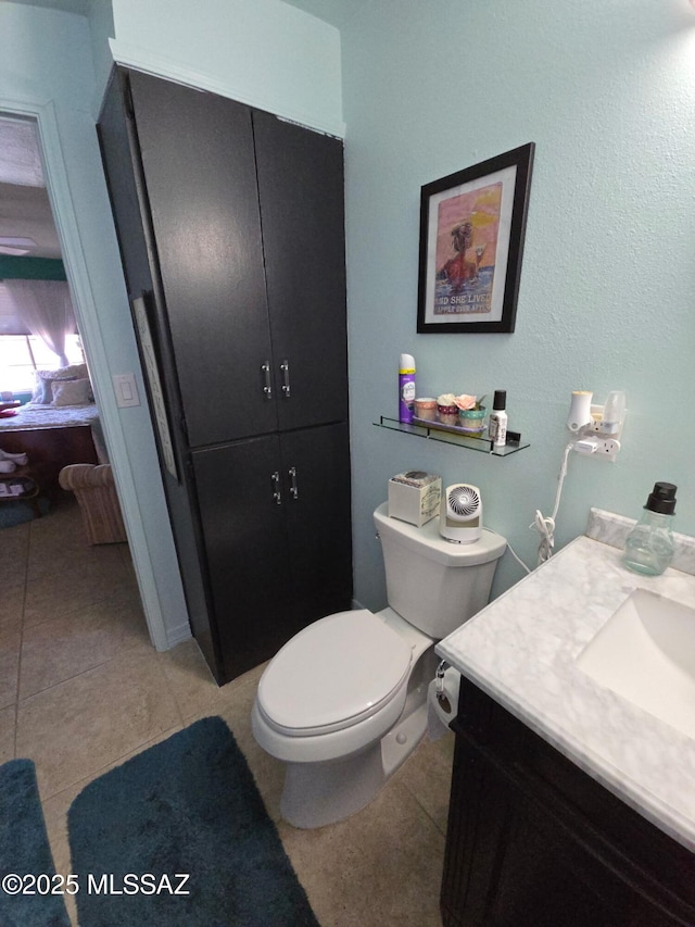 ensuite bathroom featuring toilet, vanity, tile patterned floors, and ensuite bathroom