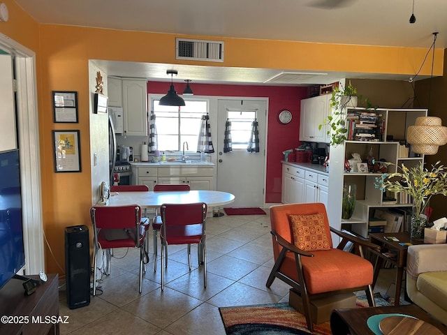 kitchen featuring white cabinets, a sink, visible vents, and light countertops