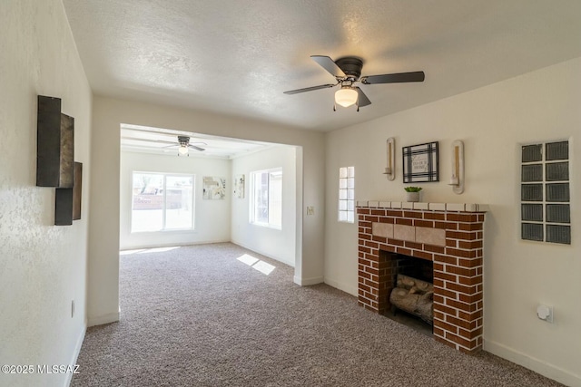 unfurnished living room with carpet, baseboards, a textured ceiling, ceiling fan, and a brick fireplace