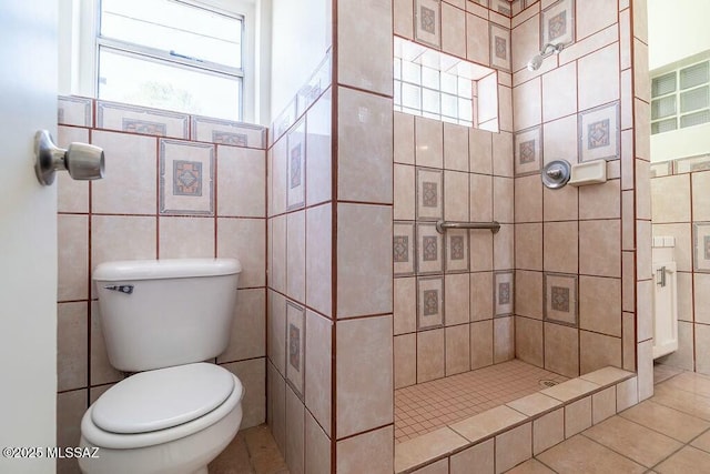 full bath featuring toilet, tile patterned flooring, tile walls, and a shower stall