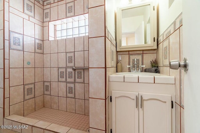 bathroom with a tile shower, decorative backsplash, and vanity