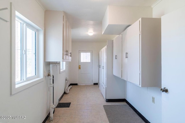 interior space with baseboards, white cabinetry, visible vents, and light tile patterned floors