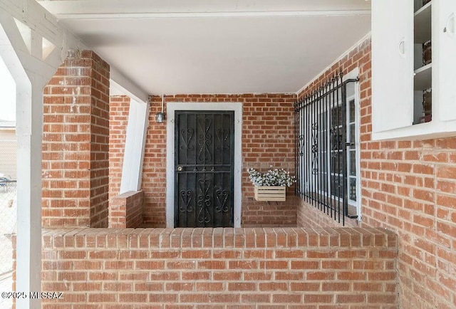 doorway to property with brick siding