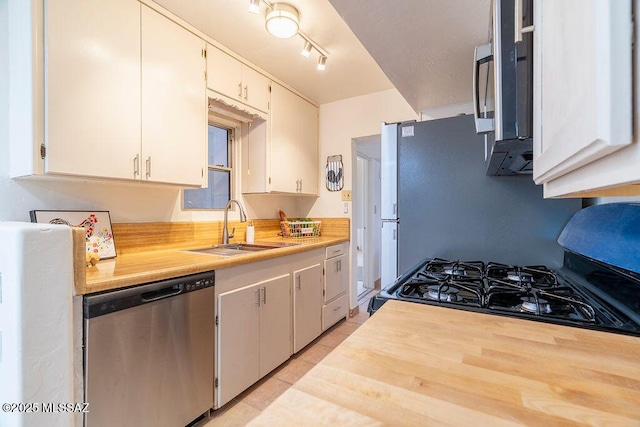 kitchen with butcher block counters, a sink, gas stove, and stainless steel dishwasher