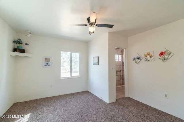 spare room with carpet flooring and a ceiling fan