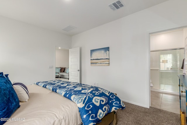 bedroom featuring connected bathroom, baseboards, visible vents, and carpet floors