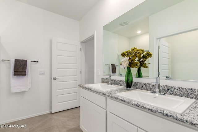 bathroom featuring double vanity, visible vents, a sink, and tile patterned flooring