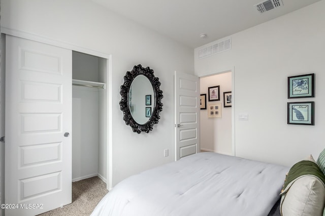 bedroom with a closet, visible vents, and carpet