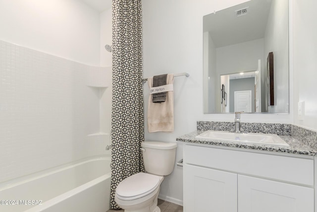 bathroom featuring toilet, vanity, shower / washtub combination, and visible vents