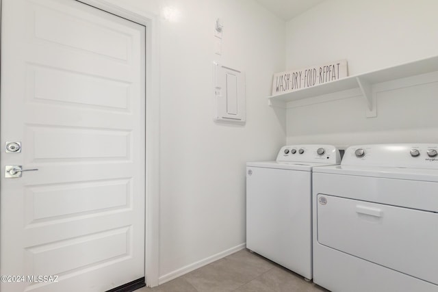 laundry area with light tile patterned floors, washing machine and dryer, baseboards, and laundry area