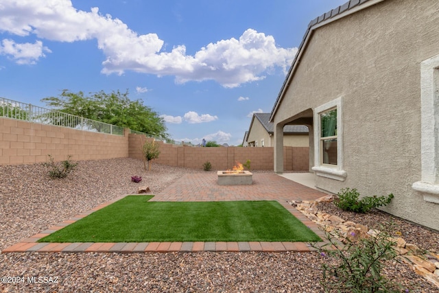 view of yard with a fenced backyard, an outdoor fire pit, and a patio area