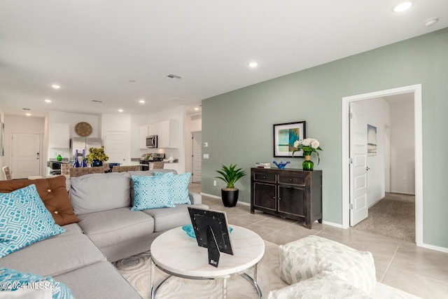 living area featuring light tile patterned flooring, baseboards, visible vents, and recessed lighting