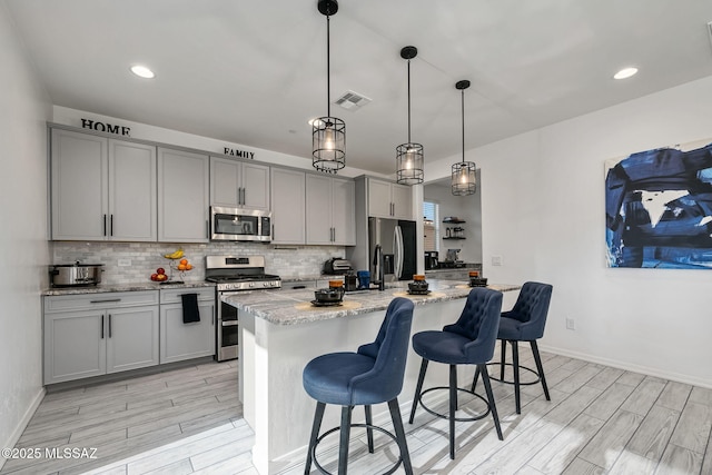 10150 S Rolling Water Dr, Vail, AZ 85641 - kitchen with backsplash, appliances with stainless steel finishes, gray cabinets, and light wood-type flooring