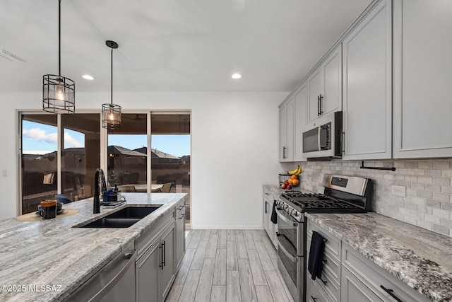 10150 S Rolling Water Dr, Vail, AZ 85641 - kitchen with a sink, stainless steel appliances, tasteful backsplash, light wood finished floors, and baseboards