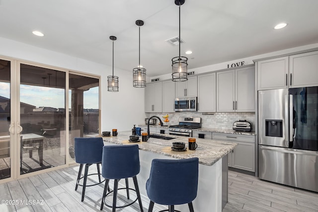 10150 S Rolling Water Dr, Vail, AZ 85641 - kitchen with a breakfast bar, a sink, stainless steel appliances, gray cabinets, and backsplash