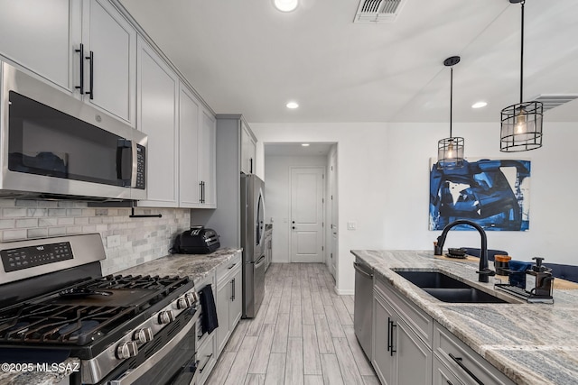 10150 S Rolling Water Dr, Vail, AZ 85641 - kitchen with light stone countertops, light wood-style flooring, appliances with stainless steel finishes, and decorative backsplash