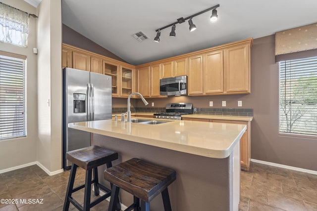 kitchen with light countertops, visible vents, stainless steel appliances, lofted ceiling, and a sink