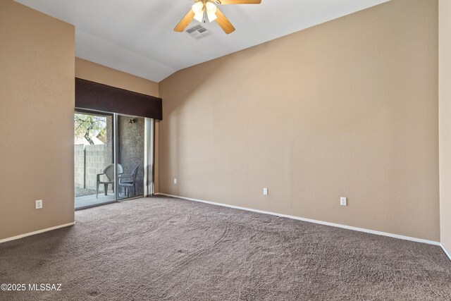carpeted empty room with baseboards, lofted ceiling, ceiling fan, and visible vents