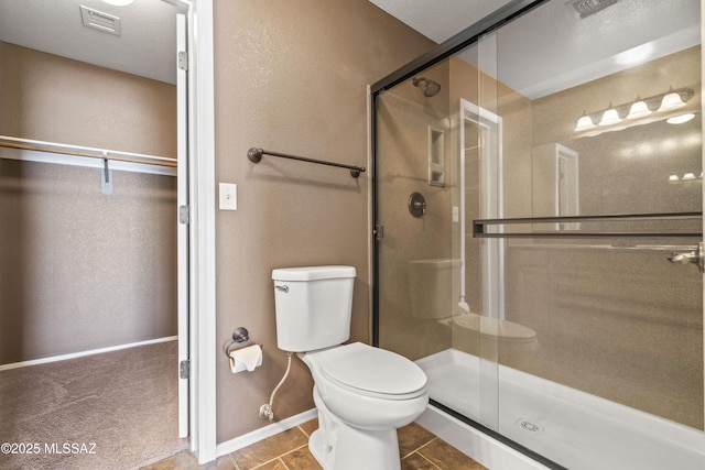 bathroom with baseboards, visible vents, a stall shower, and toilet