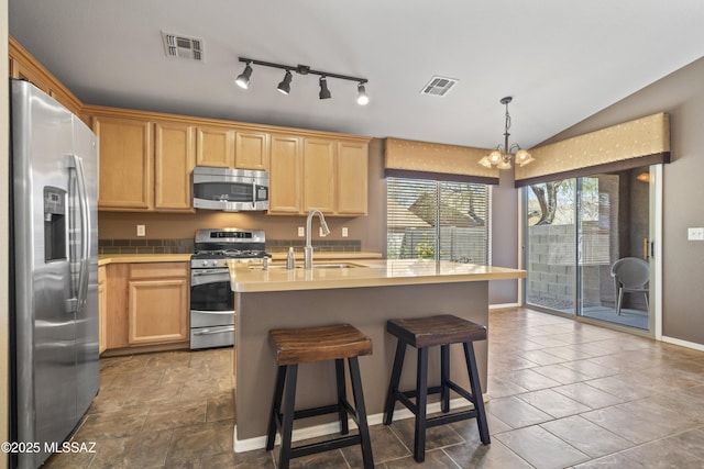 kitchen featuring light countertops, a sink, appliances with stainless steel finishes, light brown cabinets, and visible vents