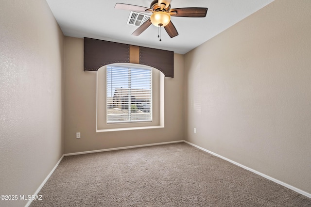 carpeted spare room featuring baseboards, visible vents, and a ceiling fan