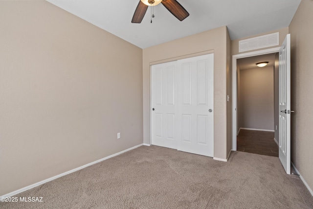unfurnished bedroom featuring baseboards, visible vents, a closet, and carpet