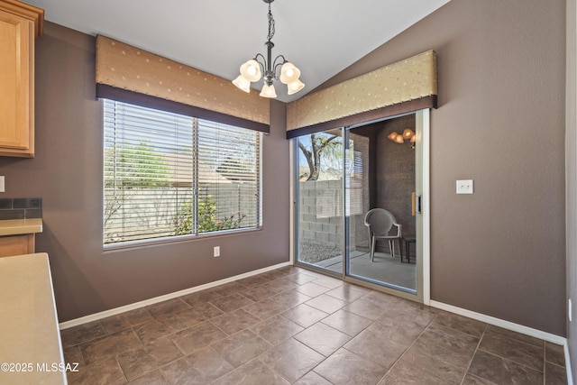 unfurnished dining area with baseboards, lofted ceiling, and an inviting chandelier