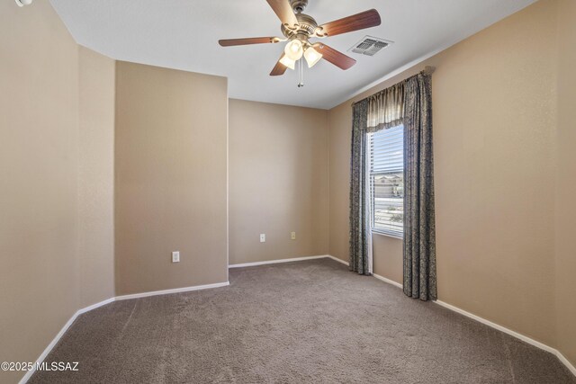 carpeted spare room featuring baseboards, ceiling fan, and visible vents