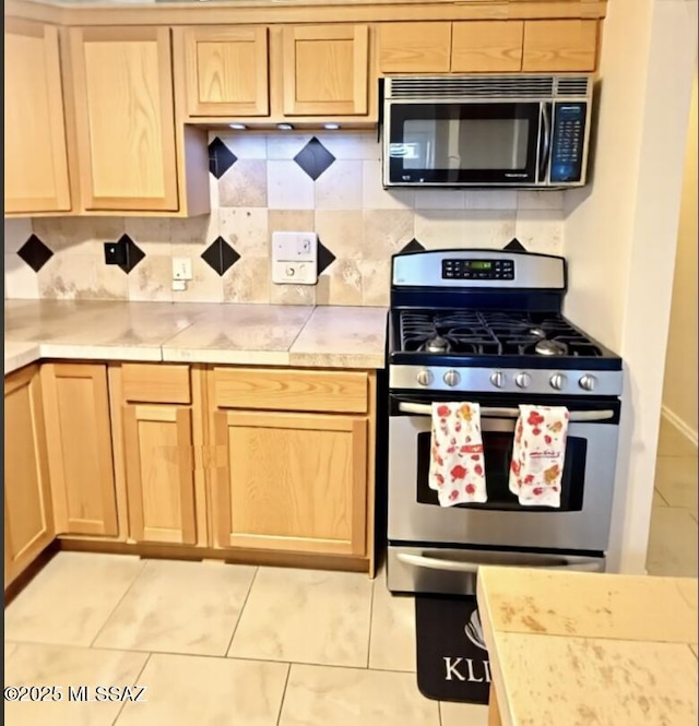 6902 E Calle Neptuno, Tucson, AZ 85710 - kitchen featuring gas stove, light brown cabinetry, light countertops, tasteful backsplash, and light tile patterned floors
