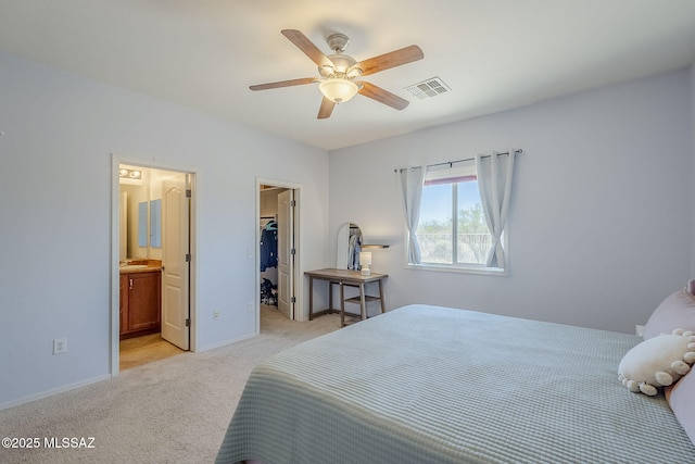bedroom with visible vents, light carpet, baseboards, ceiling fan, and a spacious closet