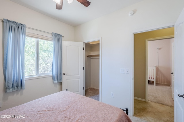 bedroom featuring a ceiling fan, baseboards, light carpet, and light tile patterned floors